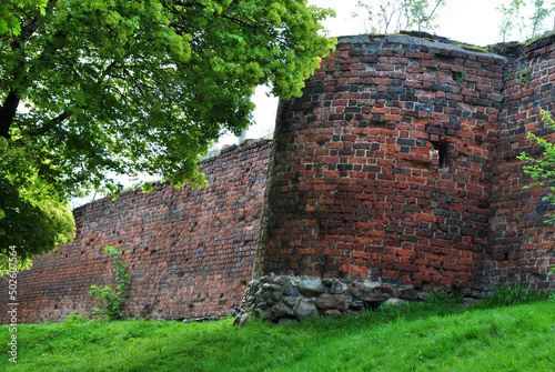 Zdjęcie architektury przedstawiające fragment murów obronnych z basztą