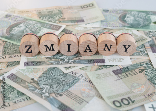 Word "zmiany" written in polish with wooden blocks standing on money, "zmiany" means "changes"