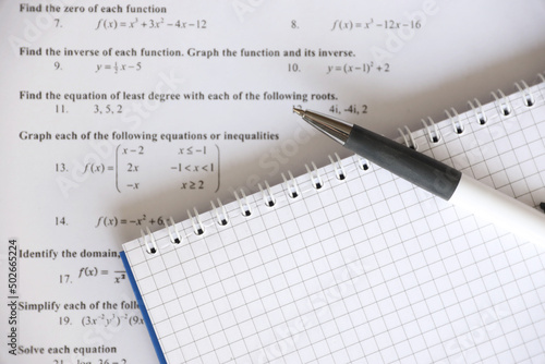 Handwriting of mathematics quadratic equation on examination, practice, quiz or test in maths class. Solving exponential equations concept.