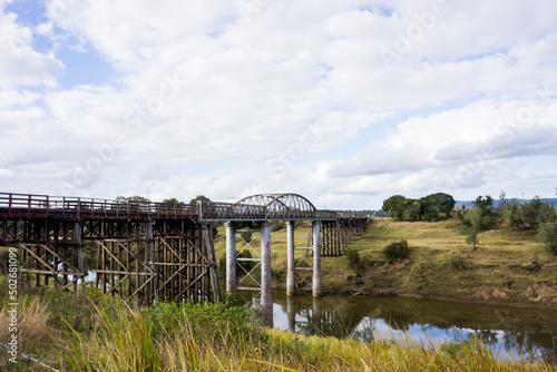 Old wooden bridge with many large trestles crossing Munna Creek at Miva in the South Burnett region of Queensland Australia