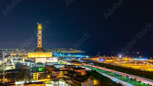 The great mosque of Algiers and the Martyr's Memorial monument Maqam El Chahid by night. Seen from the building of Les Dunes in Lavigerie, Mohammadia. highway green grass and palm trees enlightened 