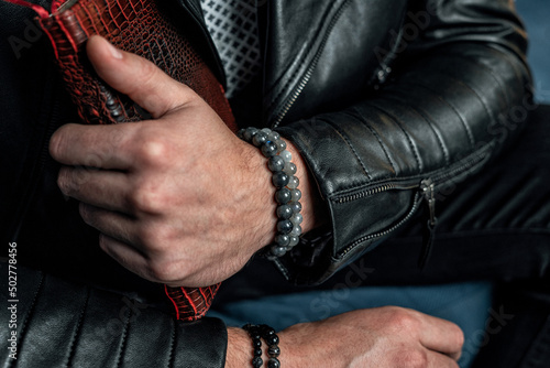 Men's bracelets made of natural stones and minerals, close-up, on the hand.