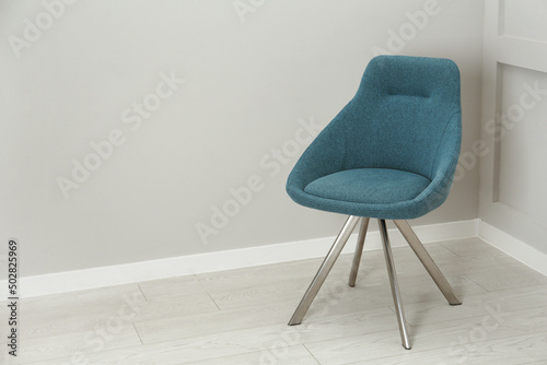 Stylish chair near light wall in room. Space for text