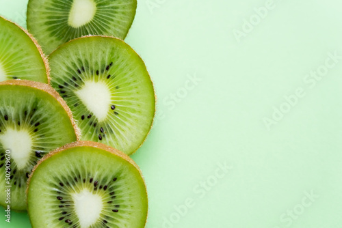 top view of sliced fresh kiwi on green.