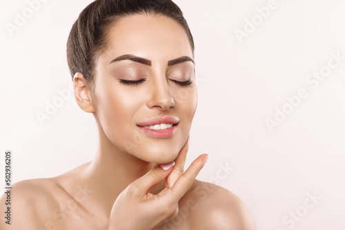 Beautiful Woman Face Skin Care. Portrait Of Attractive Young Female Applying Cream Cosmetics. Closeup Of Beauty Smiling Girl With Natural Makeup And Fresh Skin. Cosmetology. Dermatology. Spa.