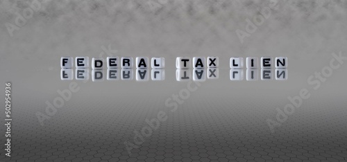 federal tax lien word or concept represented by black and white letter cubes on a grey horizon background stretching to infinity