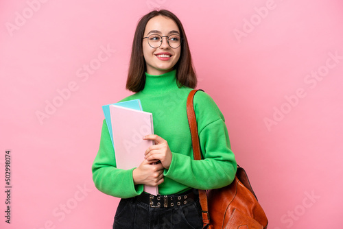 Young student Ukrainian woman isolated on pink background looking side