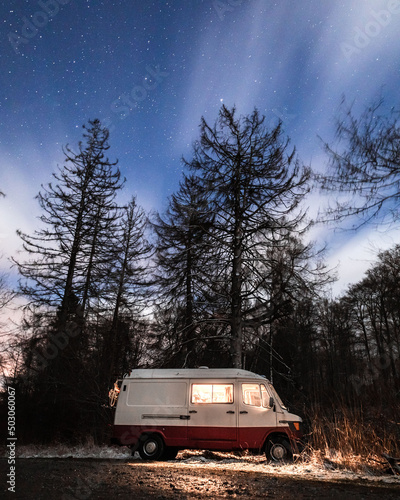 Vertical shot of a Mercedes Benz Astro van parked in a forest