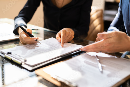 Two Businesspeople Working On Contract Paper