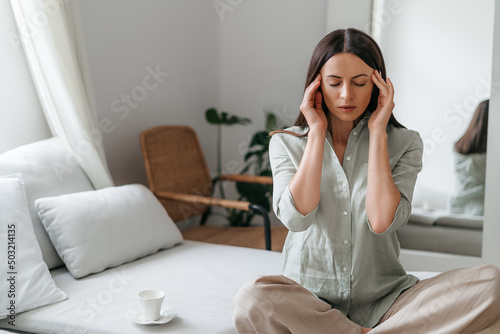 Young woman with headache in home interior