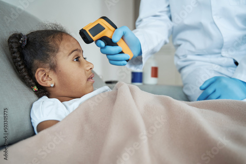 Girl is having her temperature taken with a non-contact thermometer