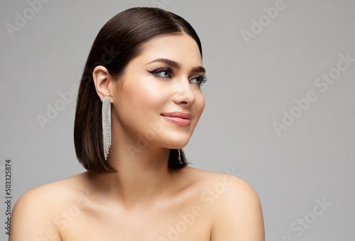 Fashion Woman Face Profile with Silver Diamond Earrings. Glamour Beauty Model with Bob Hairstyle Side view over Gray. Stylish Elegant Women Portrait with Jewelry