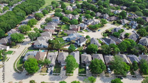 Top view an established neighborhood with matured trees and two story houses in Flower Mound, Texas, US