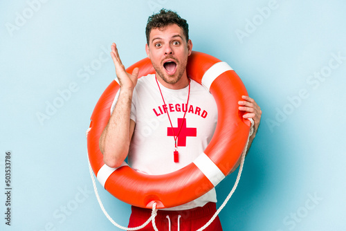 Young caucasian lifeguard man isolated on blue background surprised and shocked.