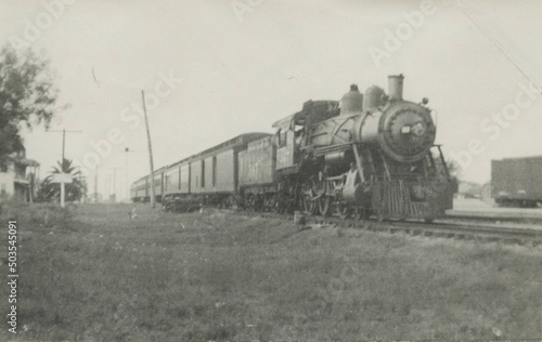 Grayscale of a steamed locomotive in 19th-century railroad