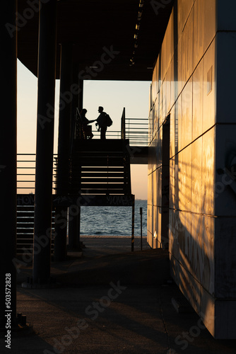 Couple on a viewpoint of a building with the sea on the backgrou