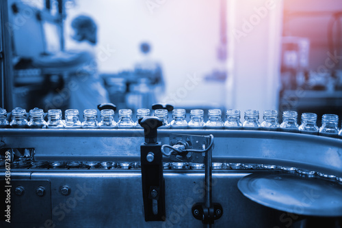 Factory interior of beverage, Production line of manufacturing and Herbal drink products, packaging juice, Glass bottles with screw caps standing on a conveyor belt. Healthy Drink Industry.