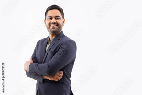 Portrait of a cheerful young businessman looking elsewhere with hands folded