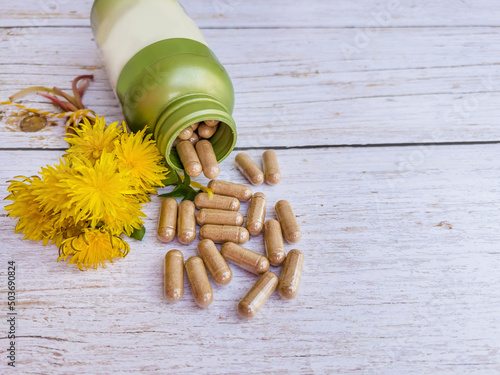 Dandelion pills and yellow dandelion flowers 