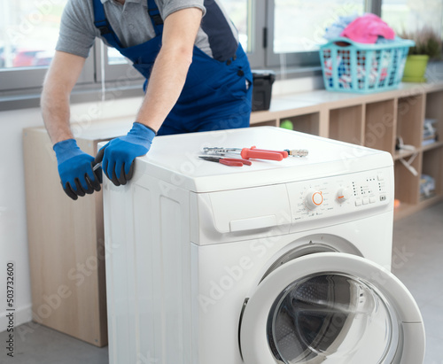 Professional repairman fixing a washer