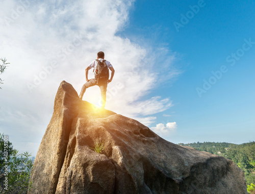 Man with backpack on top of rock