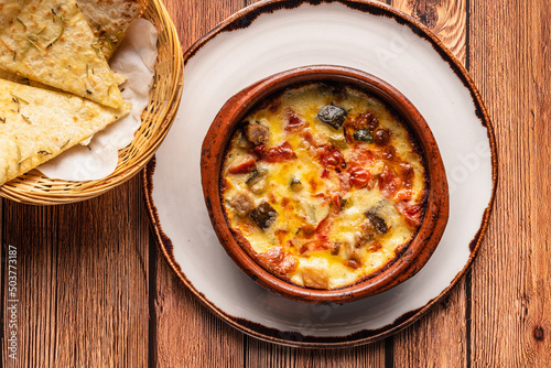 Closeup of delicious provolone cheese with vegetables on a wooden table