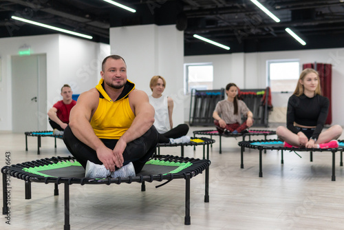 Women's and men's group on a sports trampoline, fitness training, healthy life - a concept trampoline group batut girl health, for fit team from trainer for young shaping, wellness beautiful. Studio