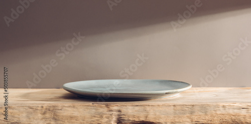Empty plate on a wooden table or bar