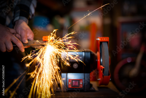 The process of sharpening scissors on metal with the release of a large number of bright sparks