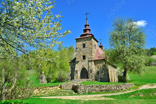 A stone church in the picturesque landscape in Huta Polanska of the Low Beskids (Beskid Niski) in spring sunny day, Poland