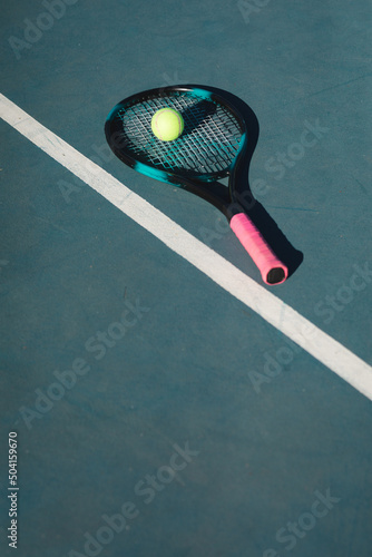 High angle view of tennis ball and racket by line on blue court during sunny day