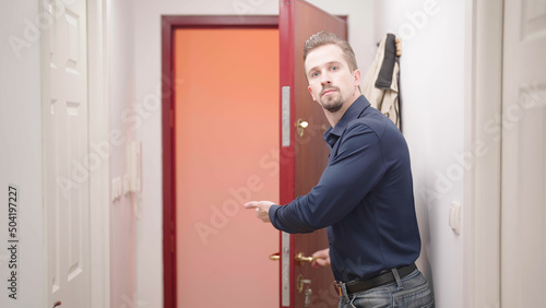 Attractive man open door and show way out with strict gesture