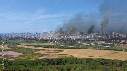 3d rendering,Large city under massive attack with destroyed buildings, aerial Drone view over Tel aviv city bombarded with smoke rising, israel,2022 3d illustration