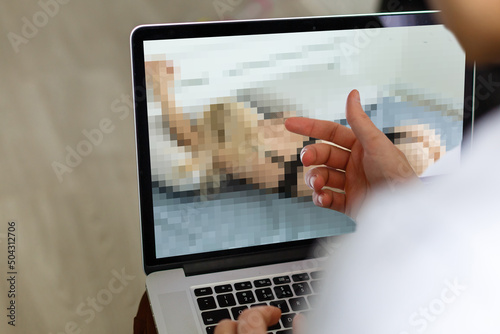 closeup of a young caucasian man watching a nude woman in his computer