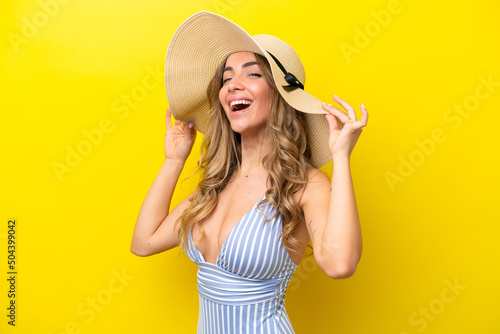 Young caucasian woman isolated on yellow background happy in swimsuit in summer holidays