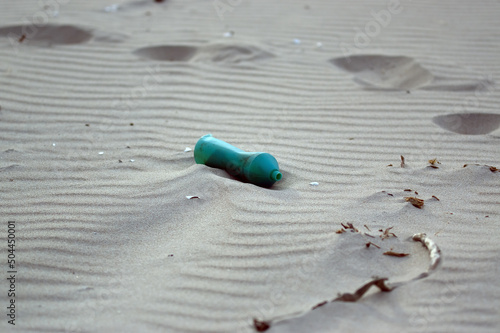 Plastikowe odpadki butelka pozostawiona na plaży. 