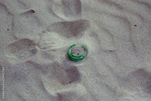 Plastikowe odpadki nakrętka od butelki pozostawiona na plaży. 