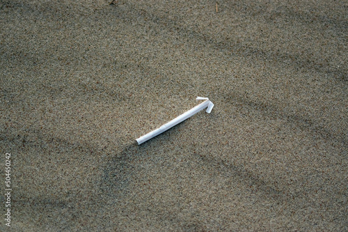 Plastikowe odpadki słomka pozostawiona na plaży. 