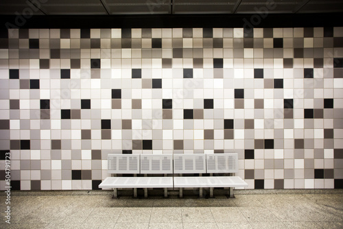 ławeczka na peronie metra z mozaiką w tle