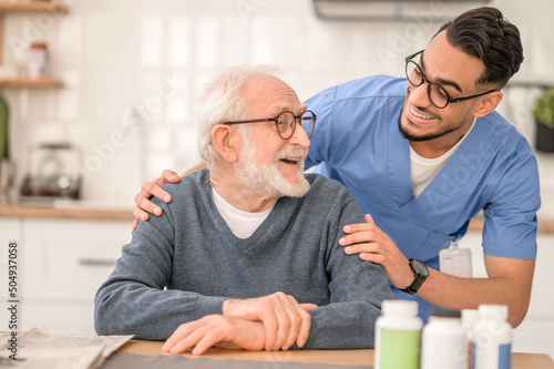 Caring healthcare worker embracing an elderly person