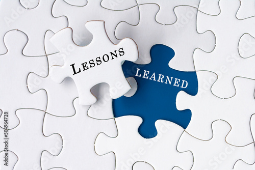 Lessons learned text on Jigsaw Puzzle over blue background.