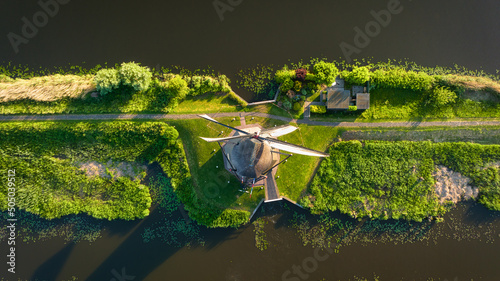 An aerial view of the windmill. Kinderdijk national park. Canals with water for agriculture. Fields and meadows. Landscape from the air.
