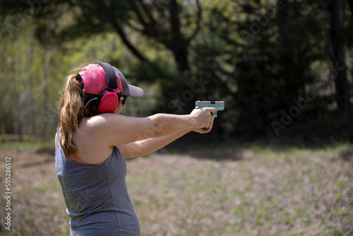 Woman shooting a handgun.