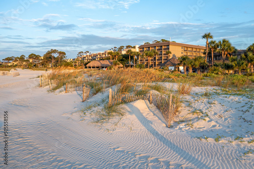 Photo of a building complex located behind sandy dunes and fencing at beach of Hilton Head Island