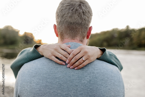 Female hands over the shoulder her fiance - engagement photos