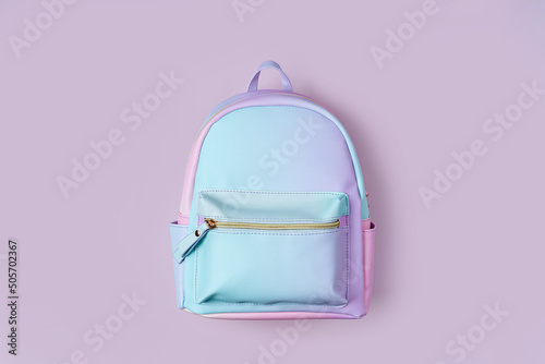 School backpack in pastel color on pink background. Concept back to school.