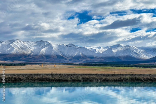 Snowcovering the Ben Ohau range with the blue blue water of the Pukaki canal in the foreground