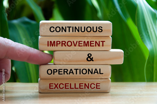 Continuous improvement and operational excellence text on wooden blocks. Business Concept