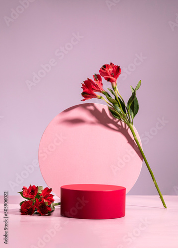 Red cylindrical podium, Cosmetic display stand with flowers on pink background