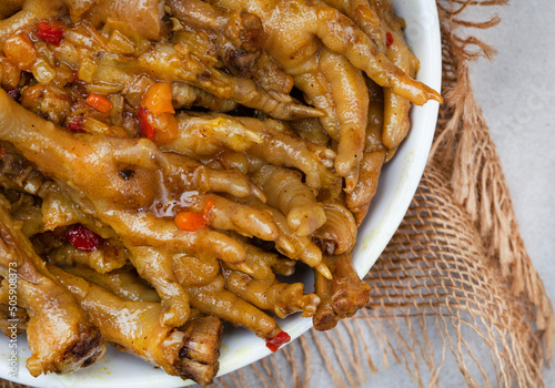  South African township delicacy, cooked chicken feet or walkie talkies with onion and sauce 